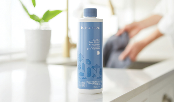 Microfiber Deep Cleaner on a counter with person washing cloth behind.
